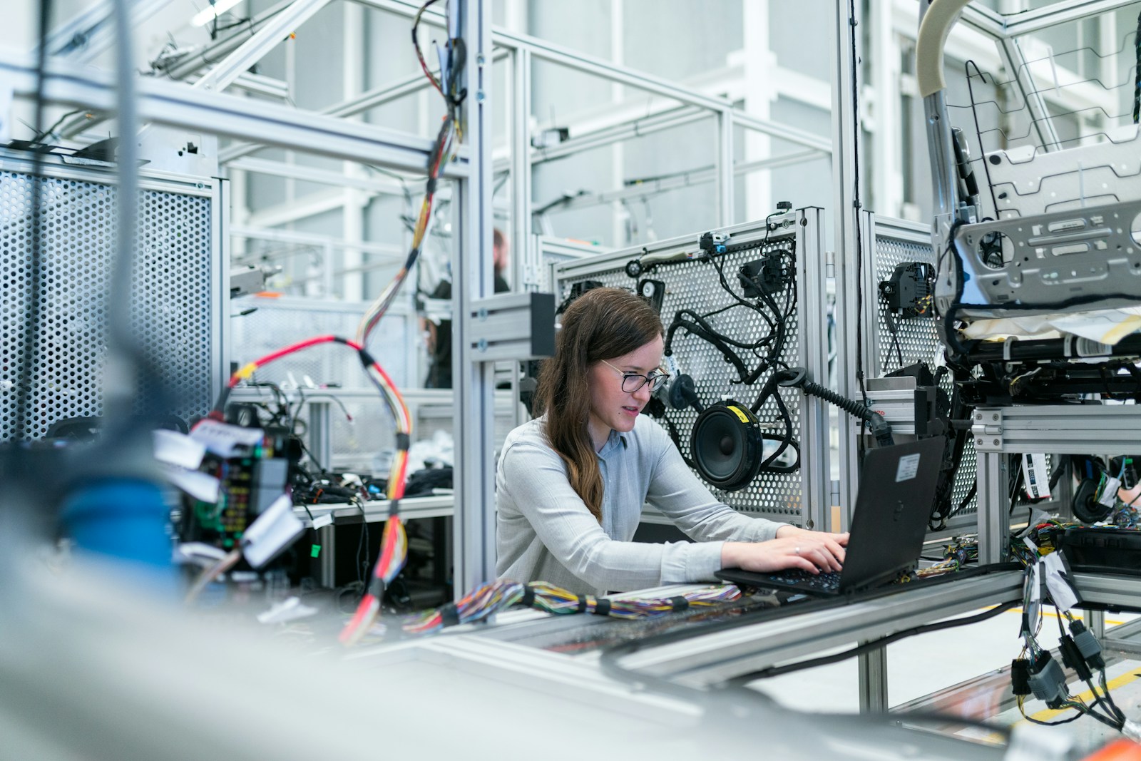 Integration engineer reviewing a robotic cell layout on a monitor beside hardware