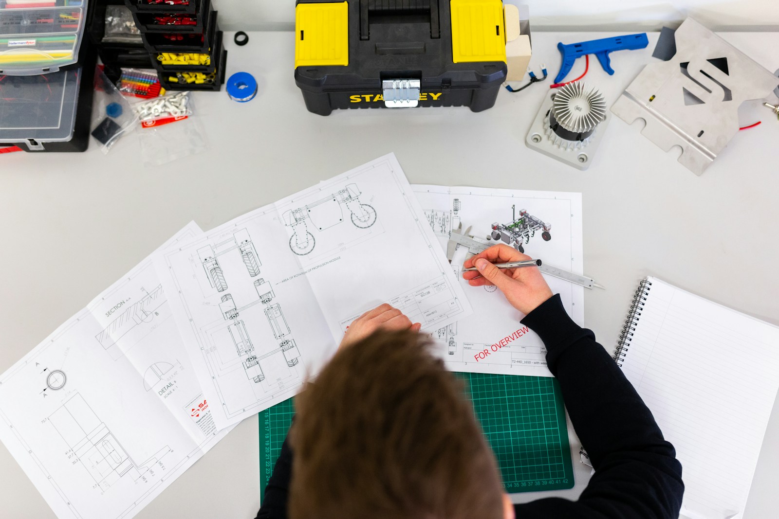 Engineer reviewing functional safety documentation beside a guarded robot cell